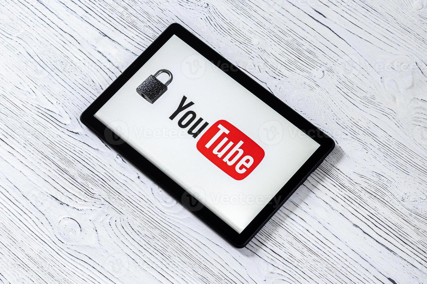 Black tablet computer on a white wooden table with a messenger youtube logo. photo