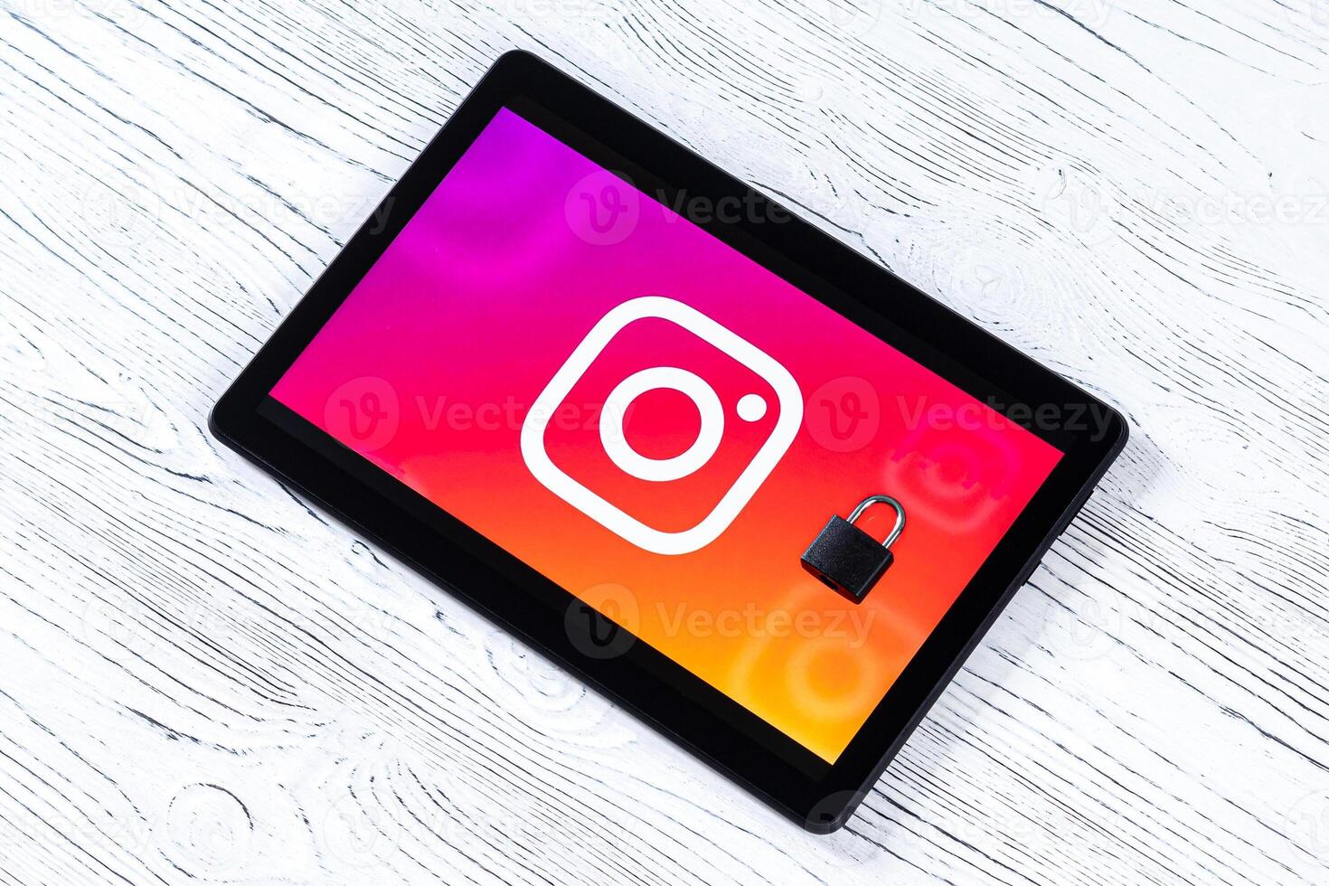Black tablet computer on a white wooden table with a messenger instagram logo. photo