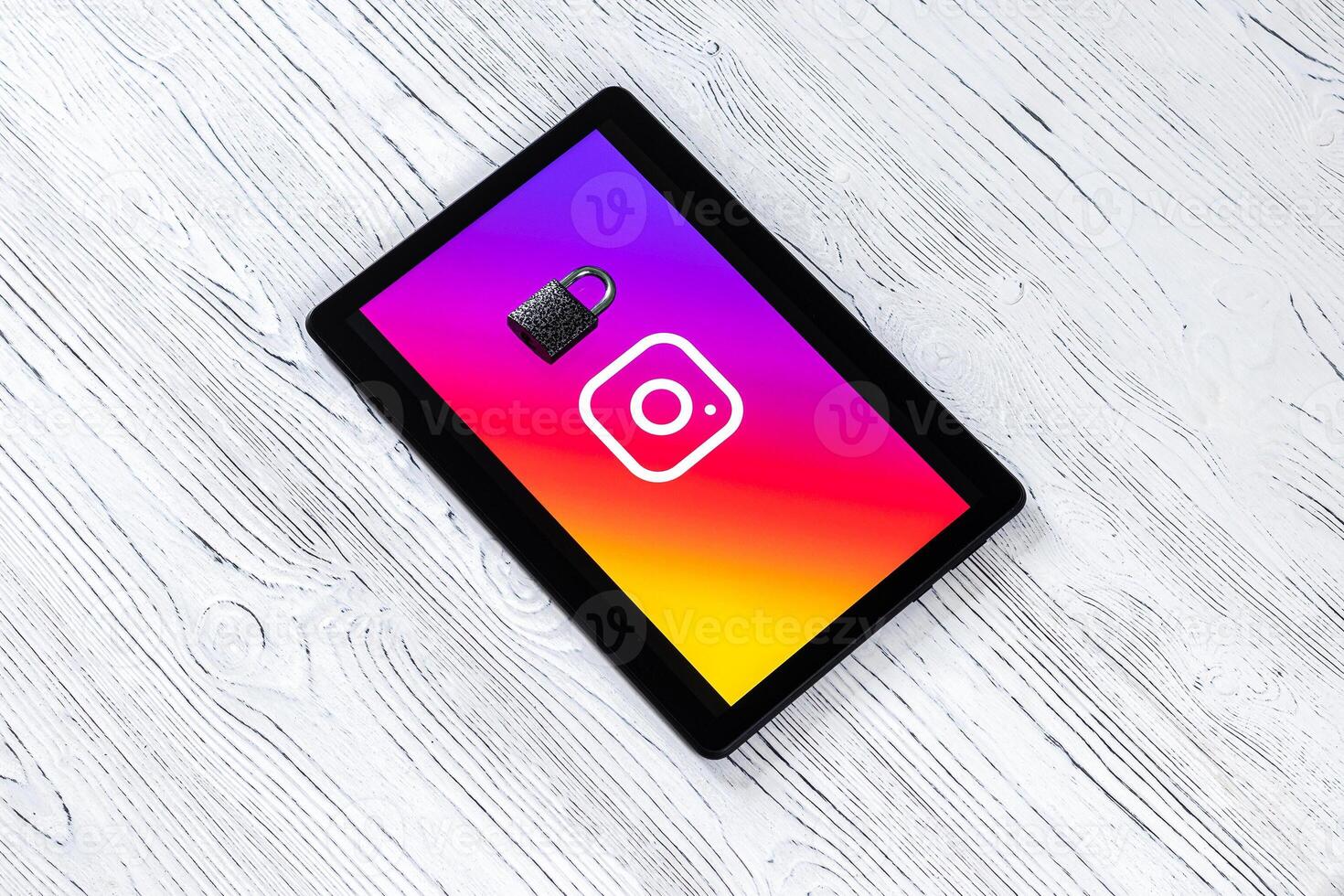 Black tablet computer on a white wooden table with a messenger instagram logo. photo
