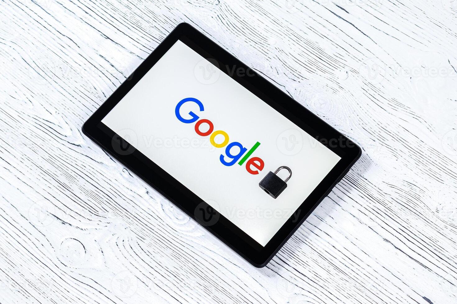 Black tablet computer on a white wooden table with a messenger google logo. photo