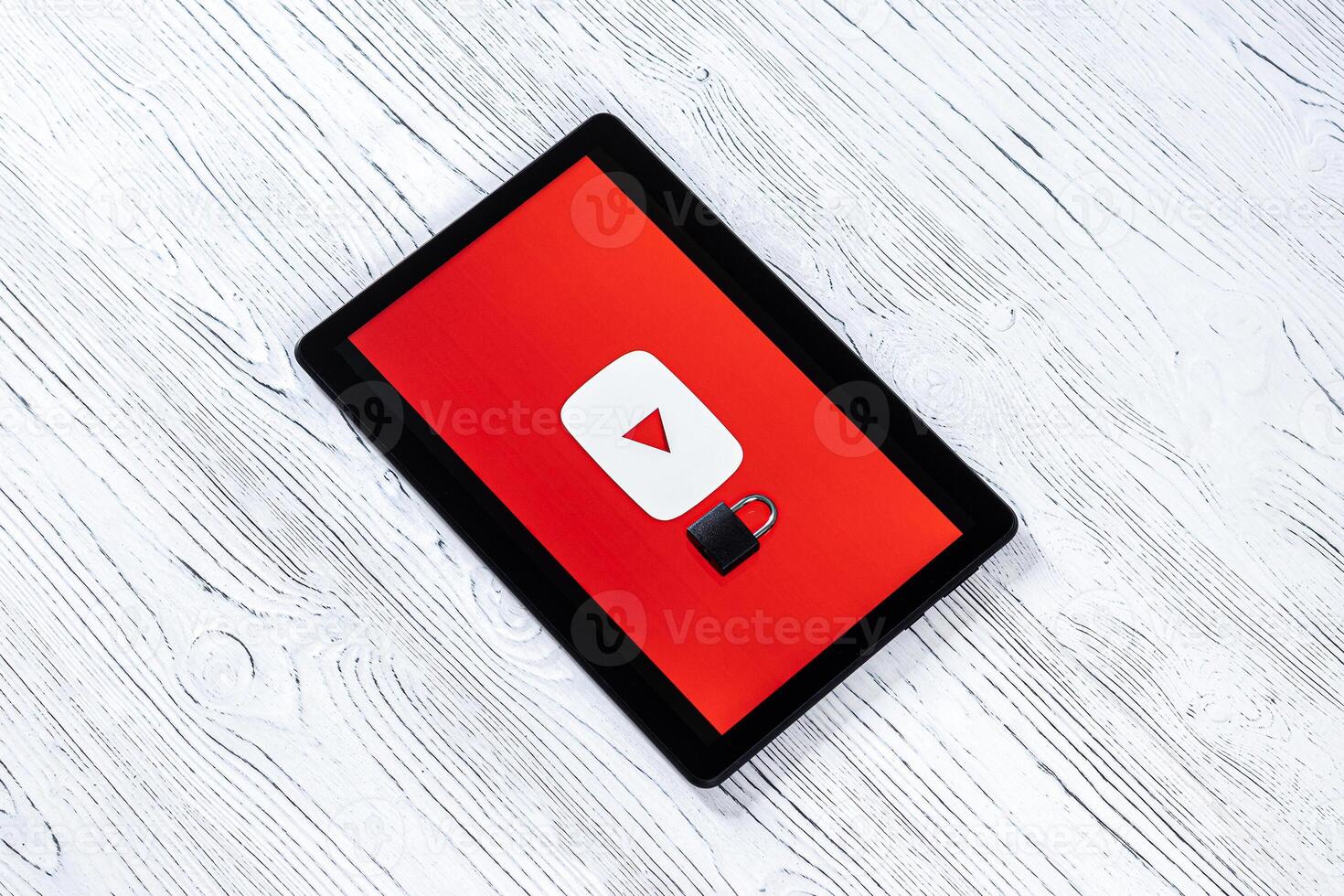 Black tablet computer on a white wooden table with a messenger youtube logo. photo