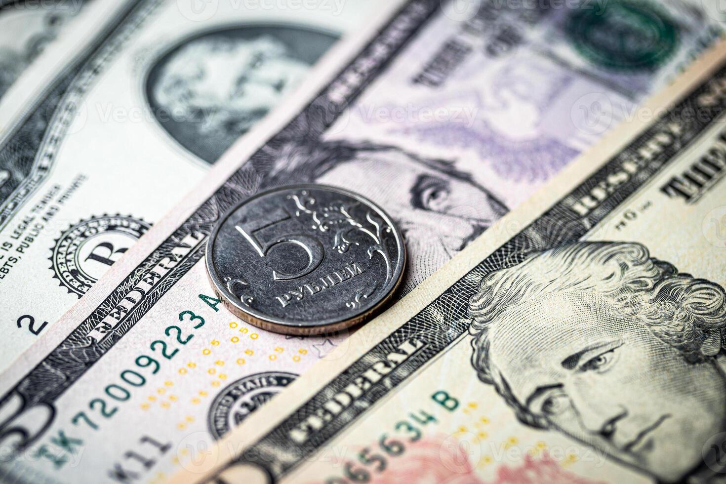 Five-ruble coin on the background of dollar bills. photo