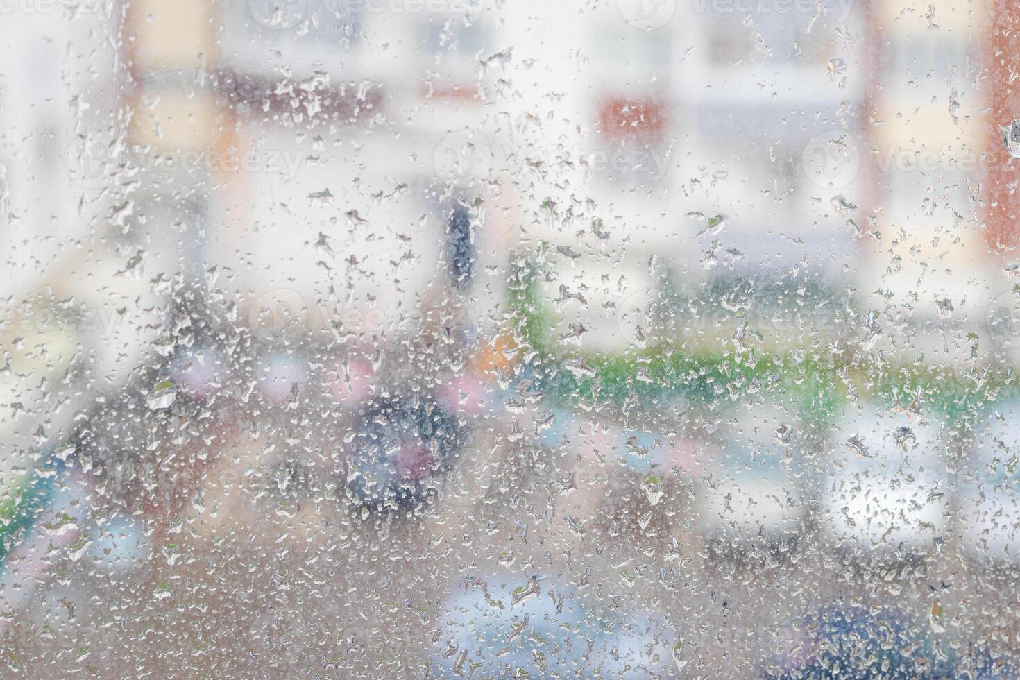 View through a rainy window on a blurred house and car parking. Bad rainy weather concept. photo