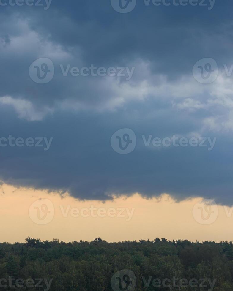 Dark blue heavy storm clouds before a thunderstorm or hurricane. Dramatic clouds in overcast weather. photo
