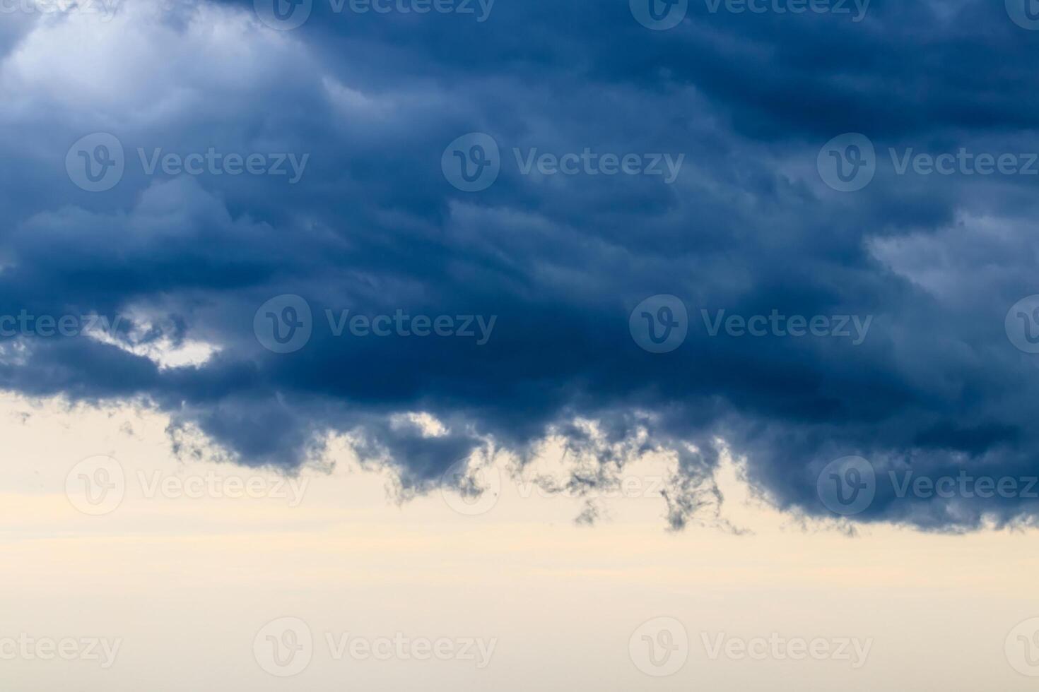 Dark blue heavy storm clouds before a thunderstorm or hurricane. Dramatic clouds in overcast weather. photo