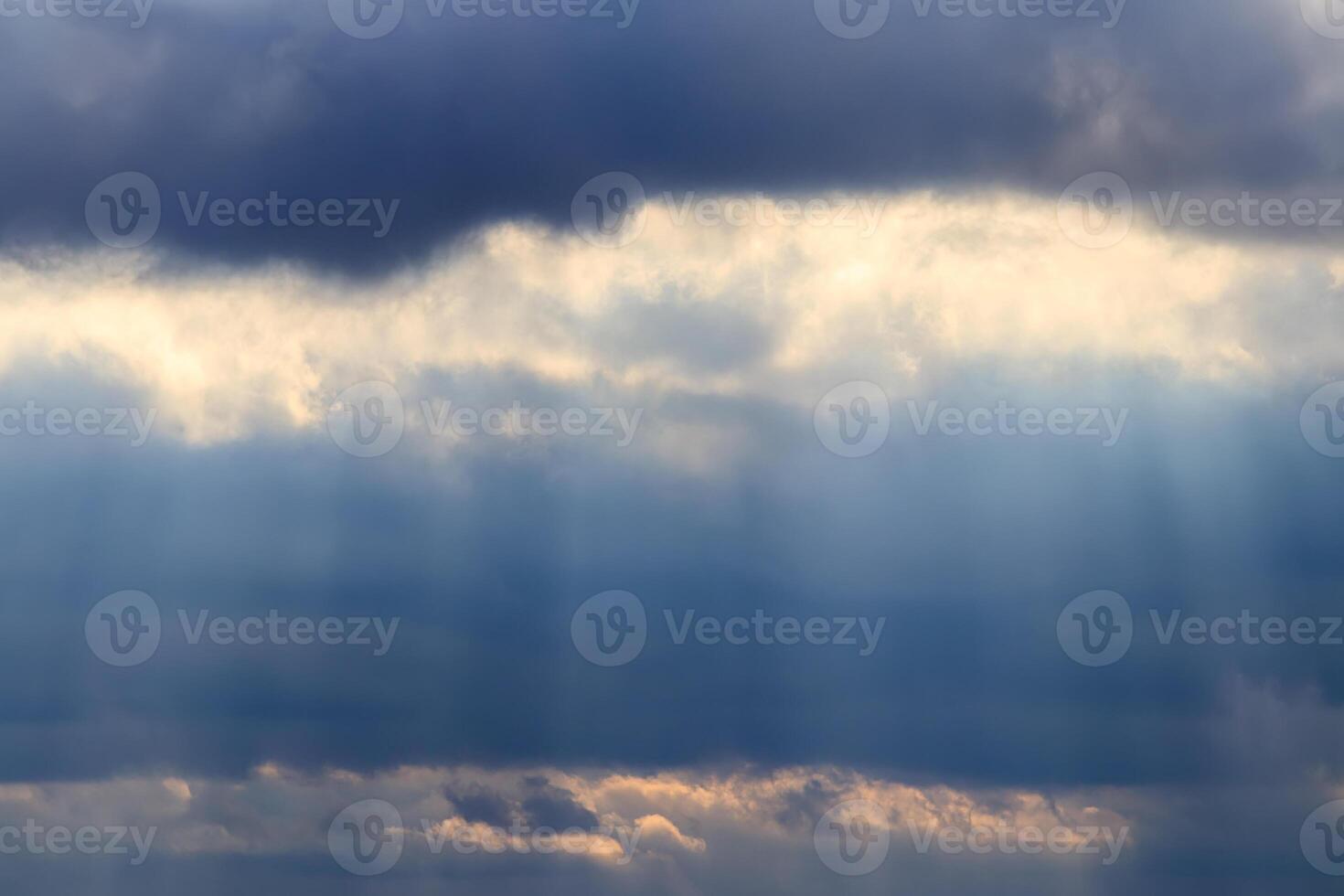 Sun rays breaking through cumulus clouds. The concept of divine light, a glimmer of hope or overcoming difficulties. Spiritual religious abstract backdrop. photo