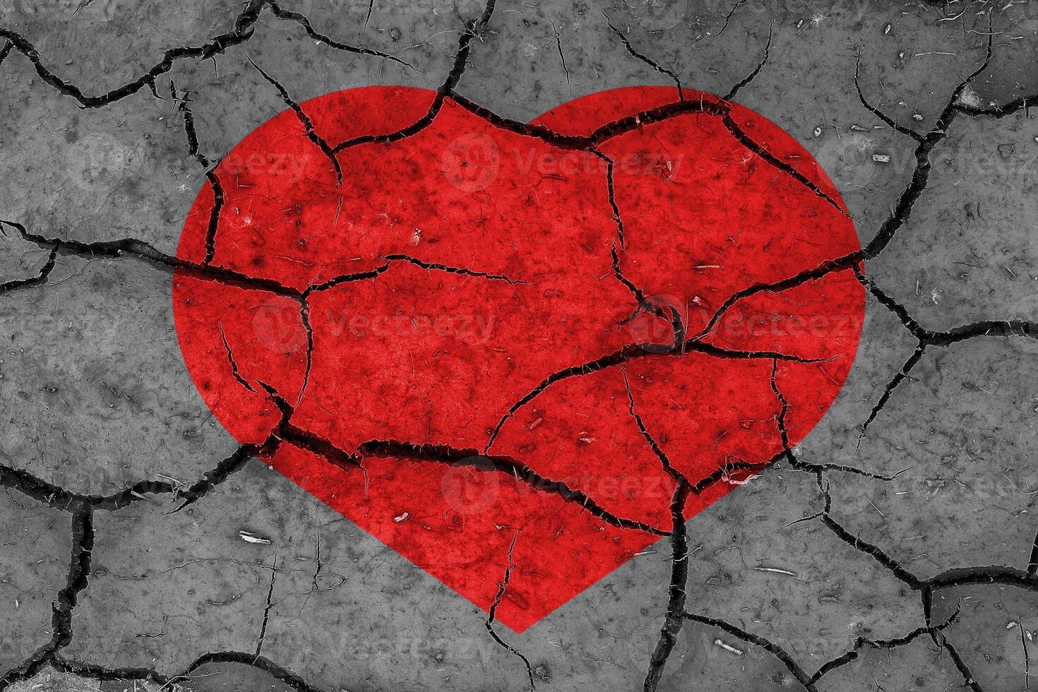 Red heart on a cracked texture. The concept of broken heart and the end of love. photo