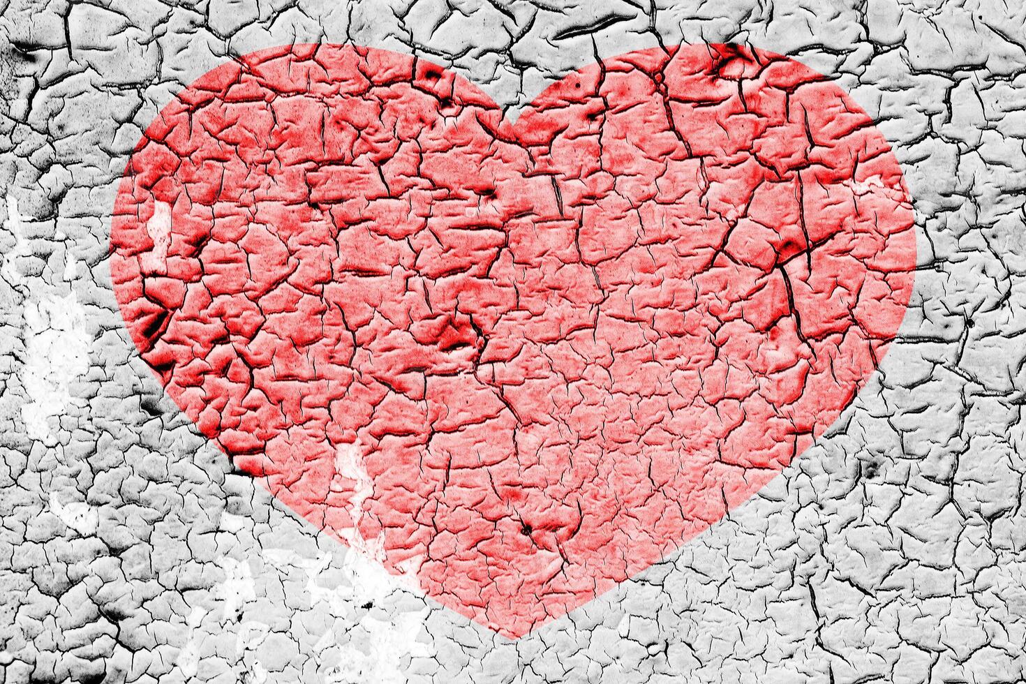 Red heart on a cracked texture. The concept of broken heart and the end of love. photo