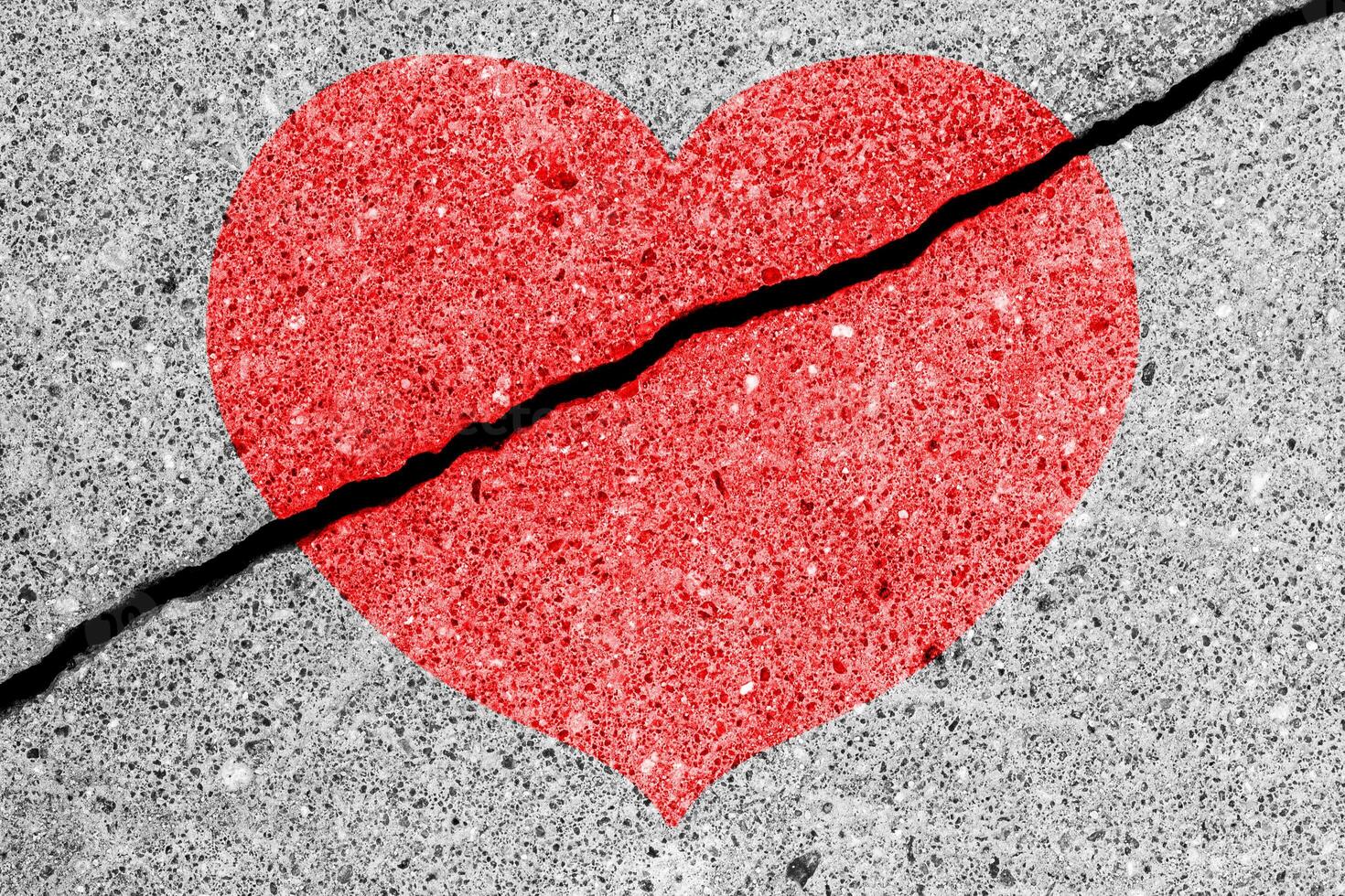 Red heart on a cracked texture. The concept of broken heart and the end of love. photo
