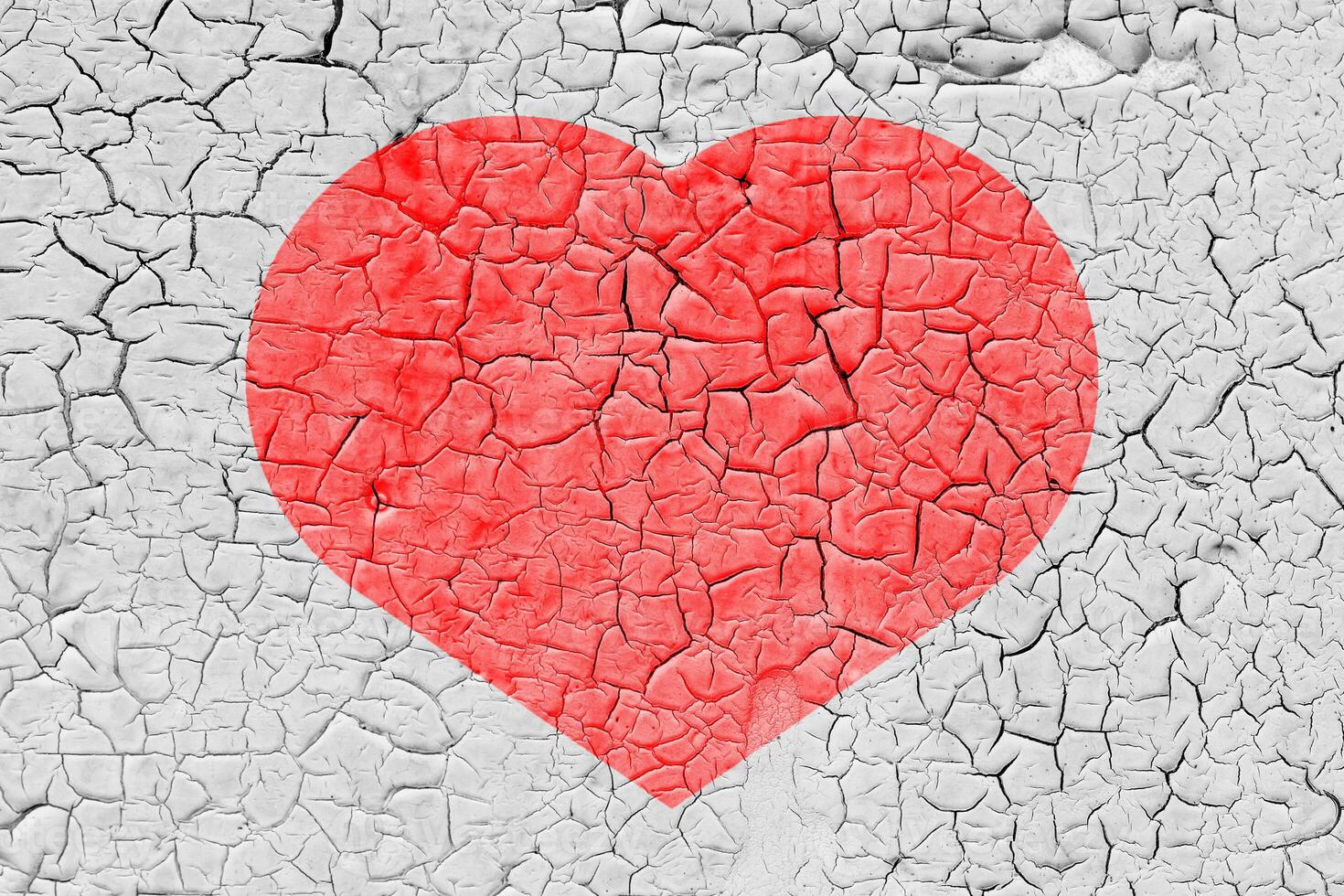Red heart on a cracked texture. The concept of broken heart and the end of love. photo
