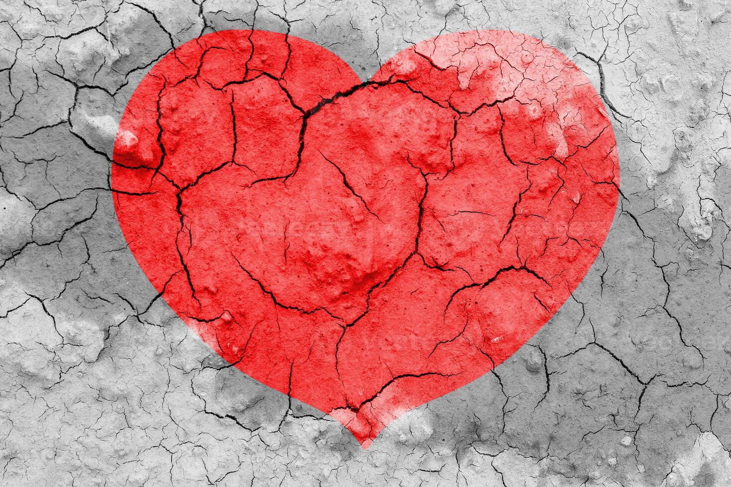 Red heart on a cracked texture. The concept of broken heart and the end of love. photo