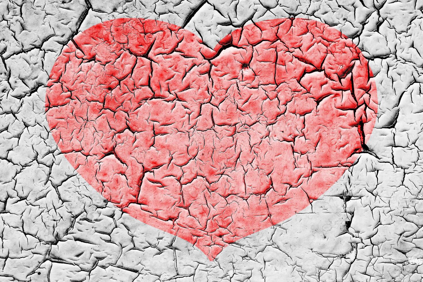 Red heart on a cracked texture. The concept of broken heart and the end of love. photo