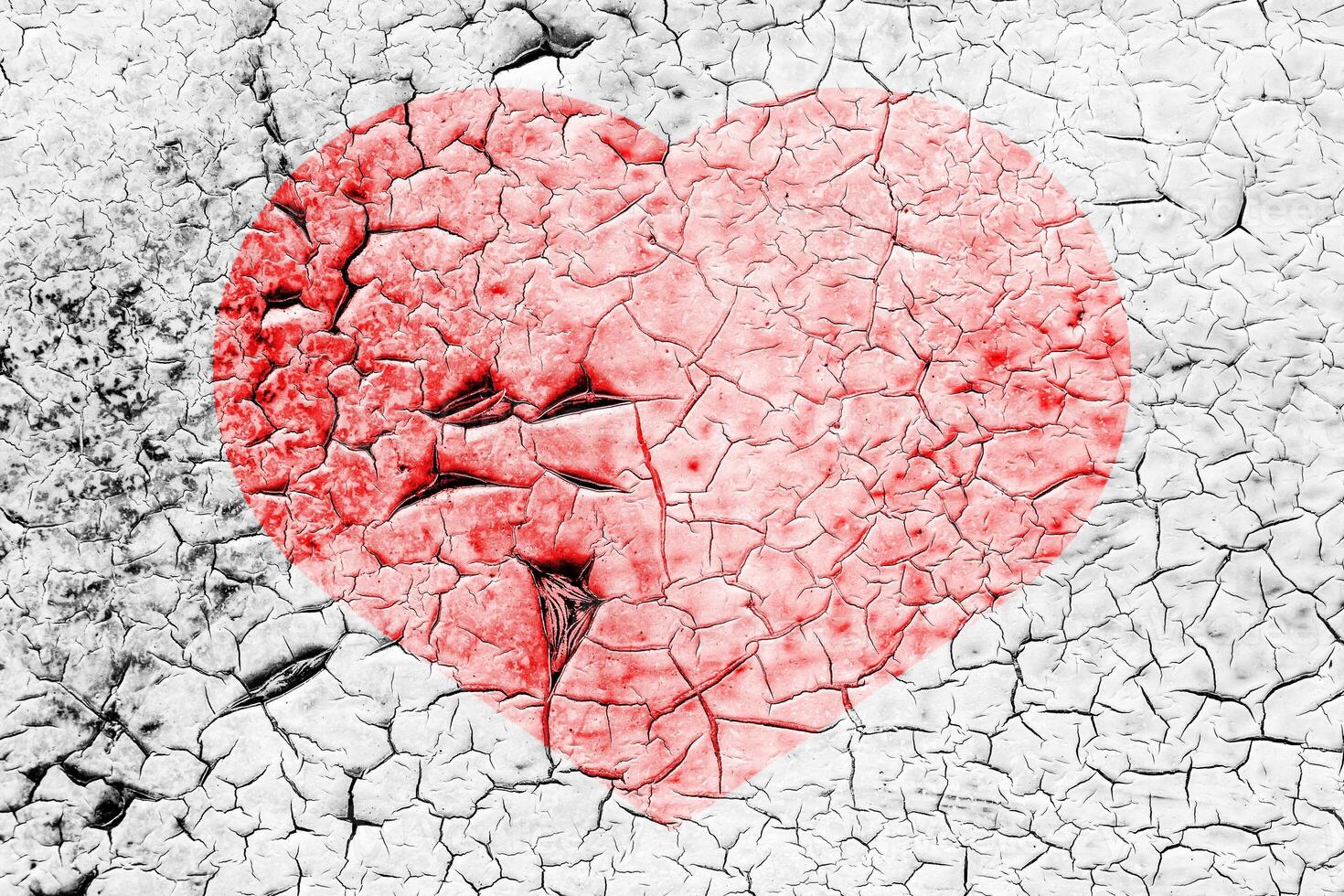 Red heart on a cracked texture. The concept of broken heart and the end of love. photo