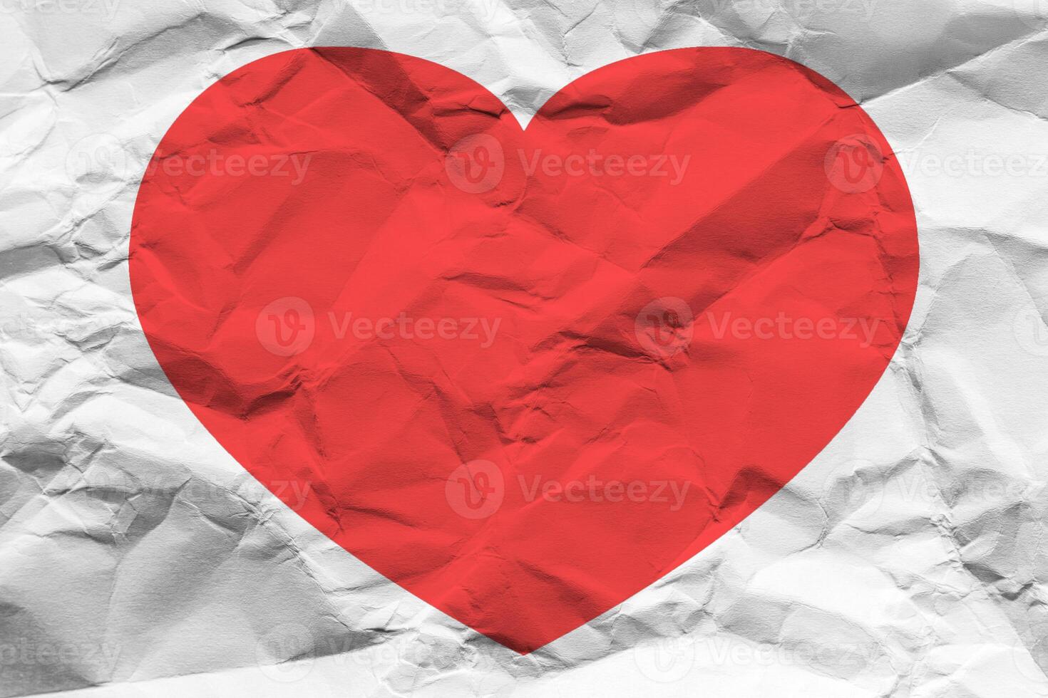 Red heart on a crumpled texture. The concept of broken heart and the end of love. photo