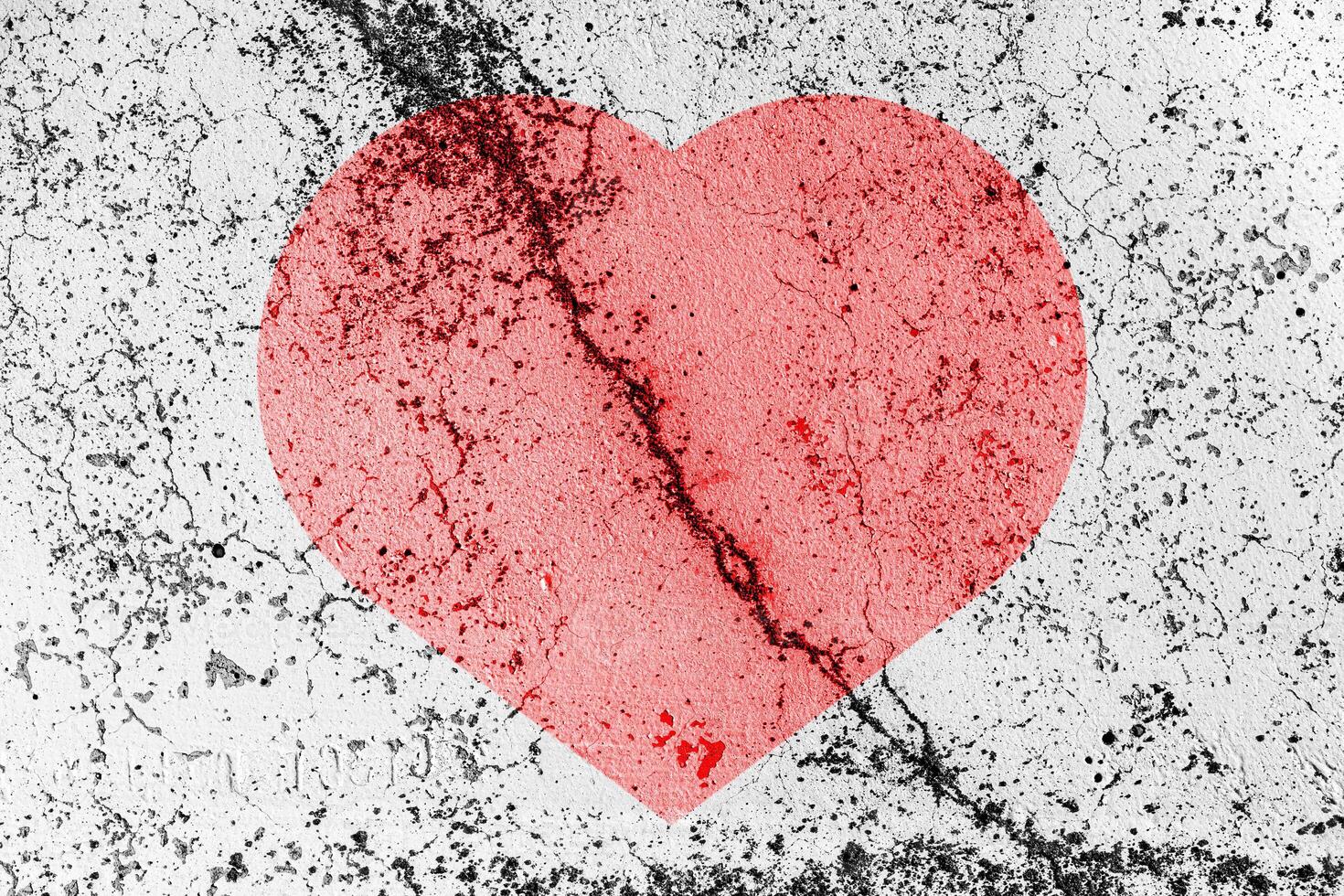 Red heart on a cracked texture. The concept of broken heart and the end of love. photo