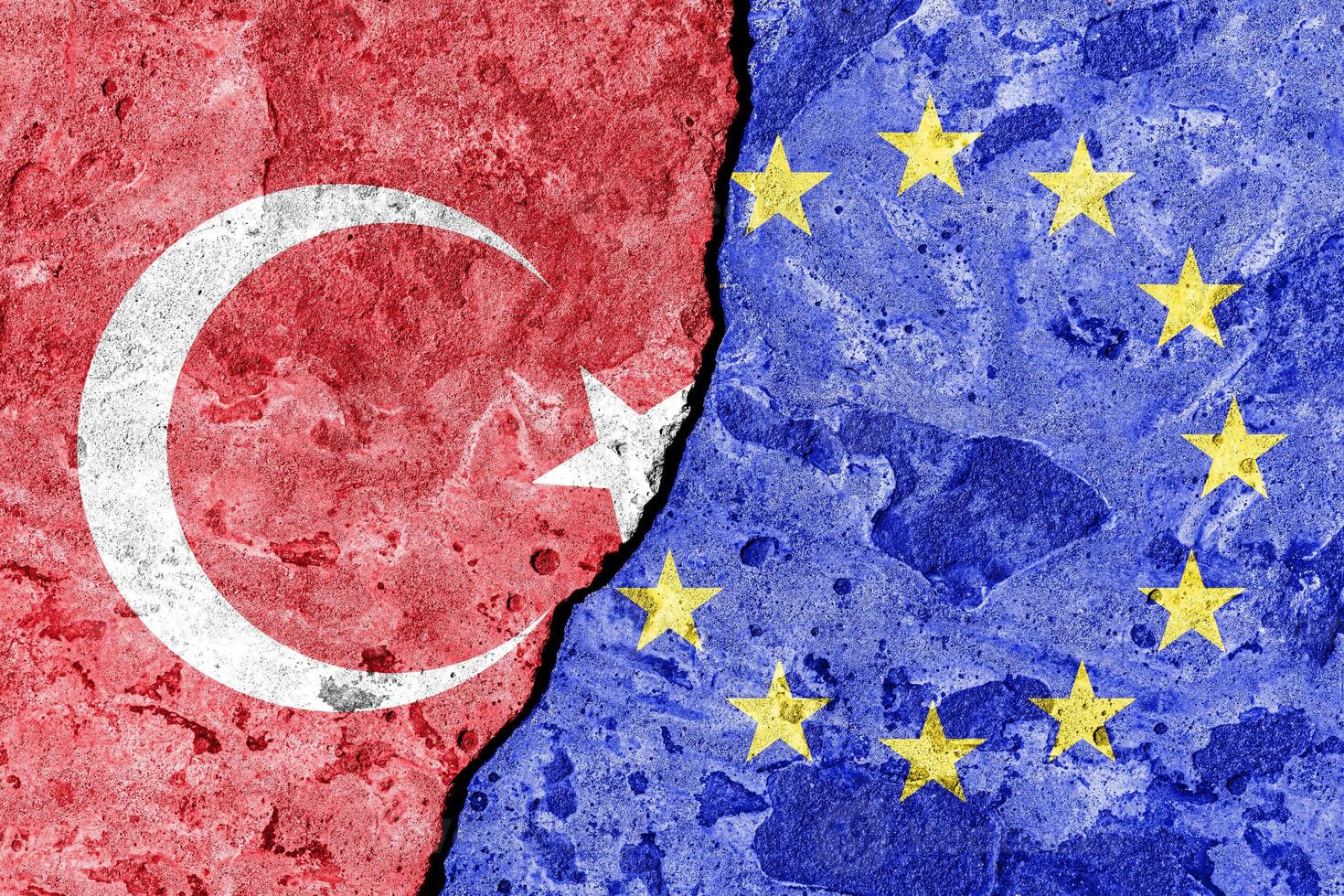 The crack between the European Union and Turkish flags on the concrete wall. The concept of sanctions, relationship problems and ban on tourism. photo