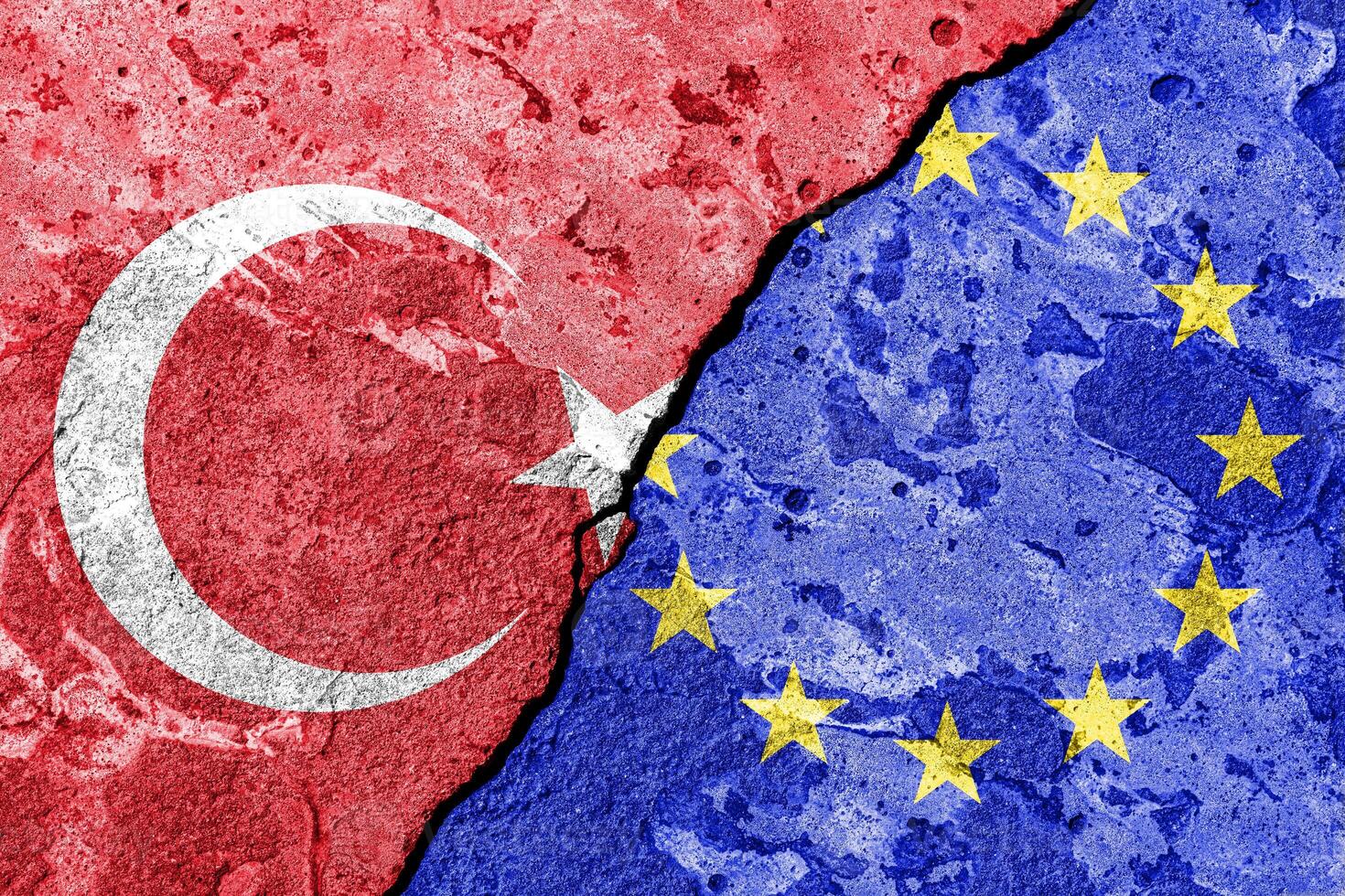 The crack between the European Union and Turkish flags on the concrete wall. The concept of sanctions, relationship problems and ban on tourism. photo