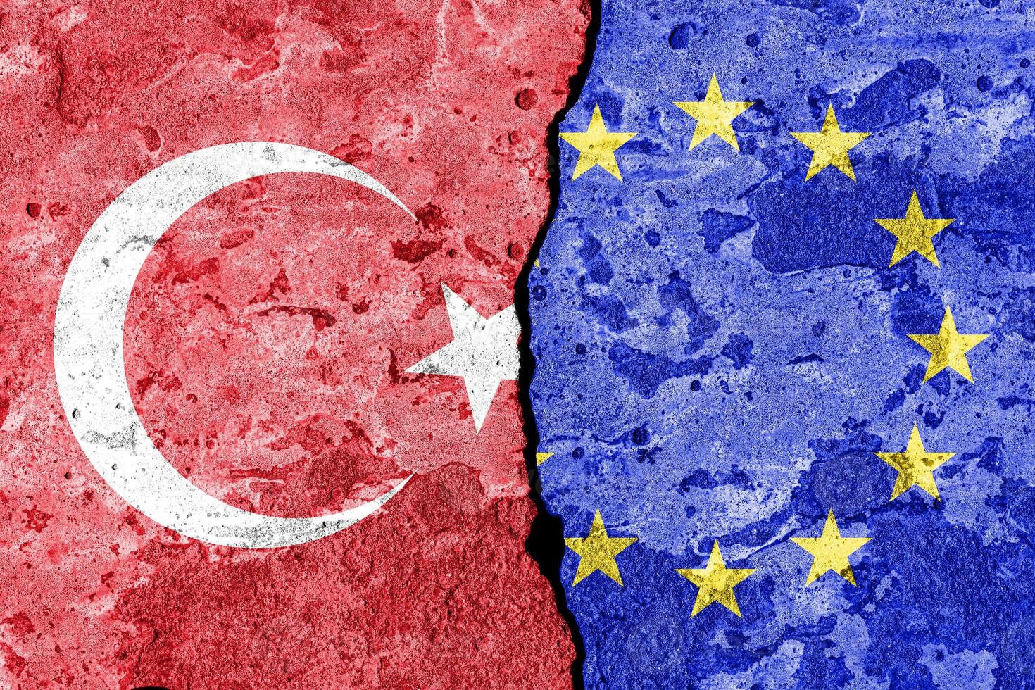 The crack between the European Union and Turkish flags on the concrete wall. The concept of sanctions, relationship problems and ban on tourism. photo