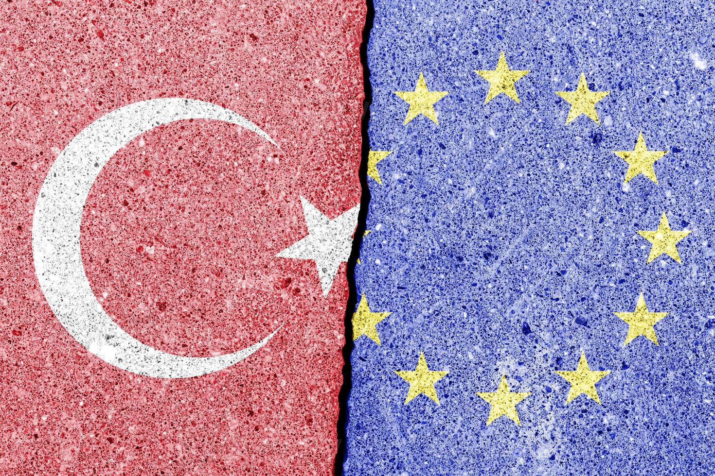 The crack between the European Union and Turkish flags on the concrete wall. The concept of sanctions, relationship problems and ban on tourism. photo