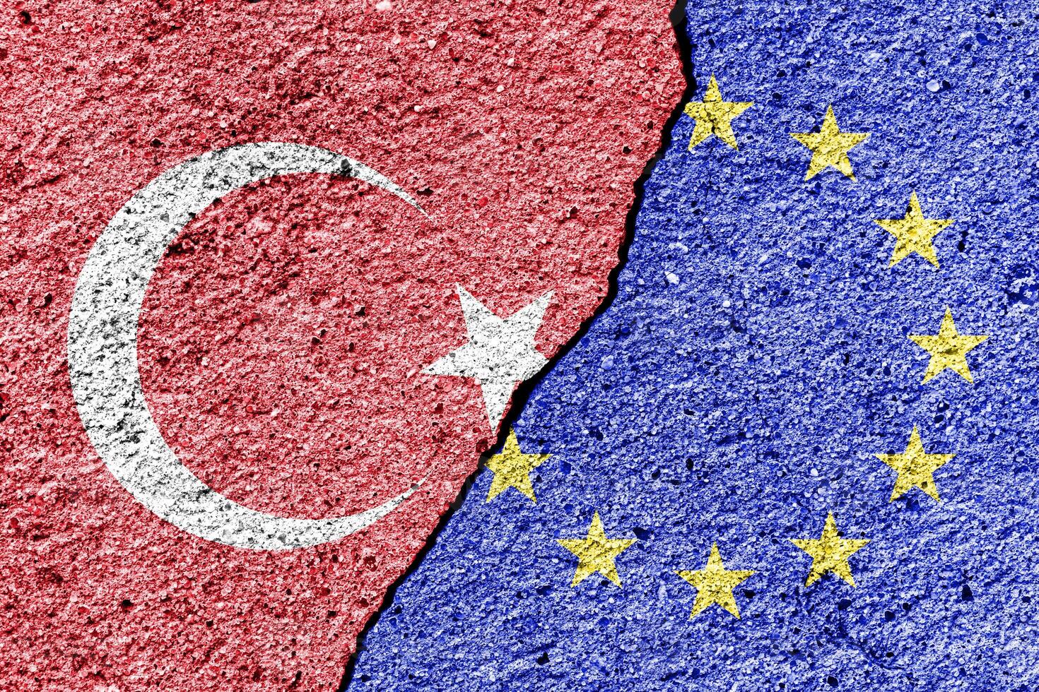 The crack between the European Union and Turkish flags on the concrete wall. The concept of sanctions, relationship problems and ban on tourism. photo