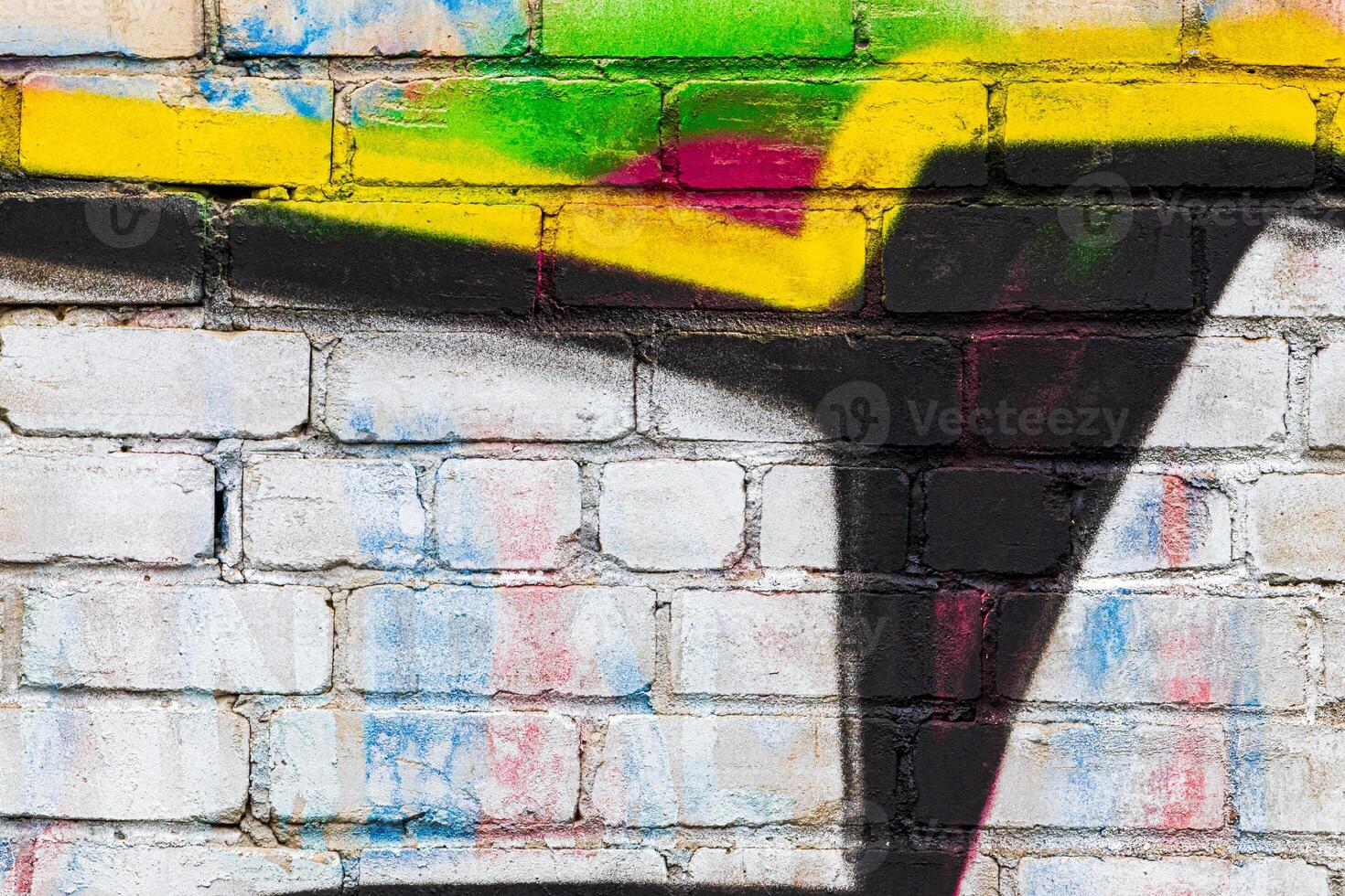 A fragment of colorful graffiti painted on a brick wall. Abstract backdrop for design. photo