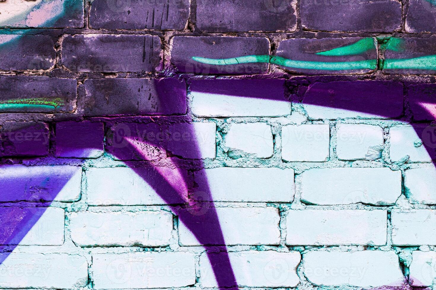 A fragment of colorful graffiti painted on a brick wall. Abstract backdrop for design. photo
