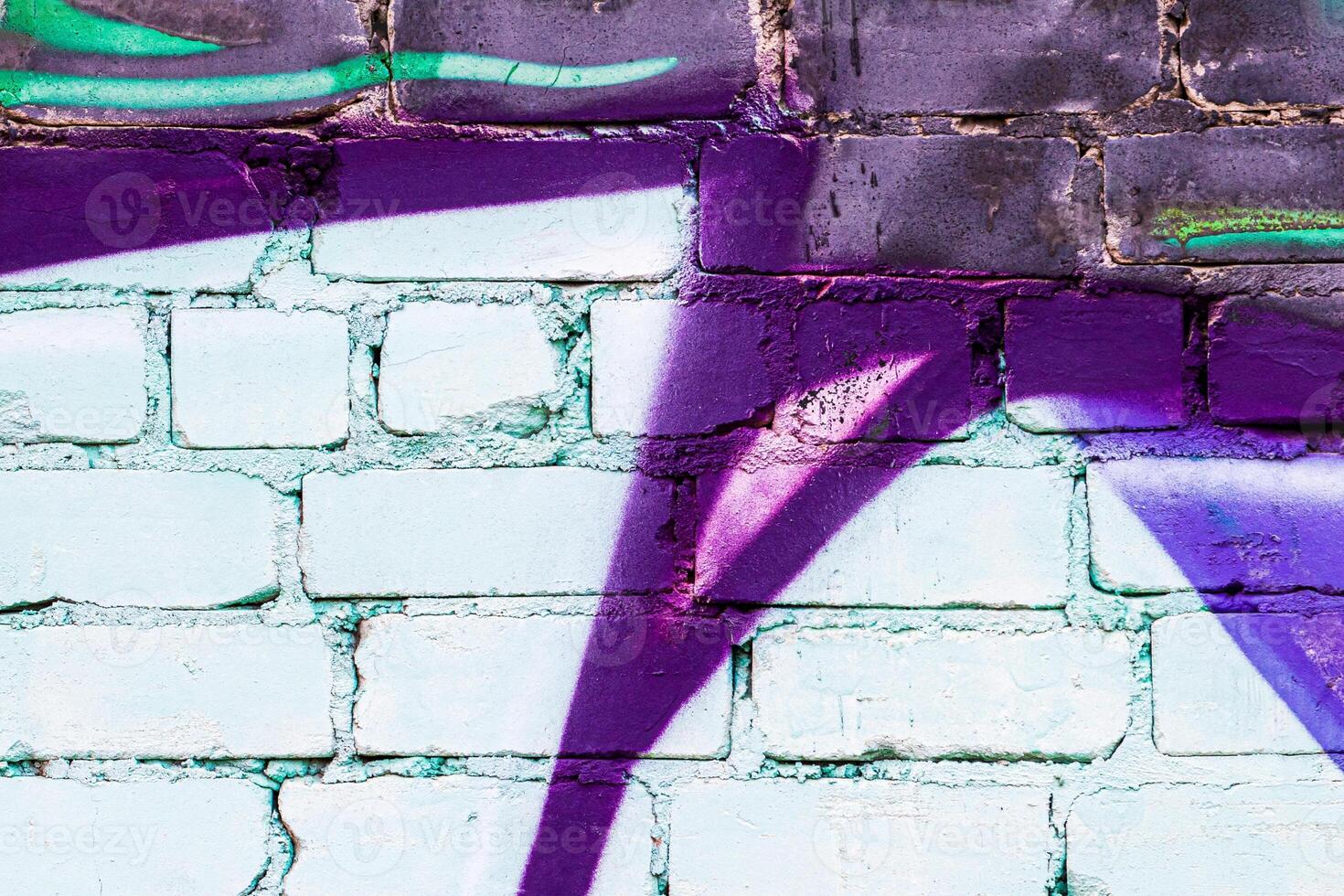 A fragment of colorful graffiti painted on a brick wall. Abstract backdrop for design. photo