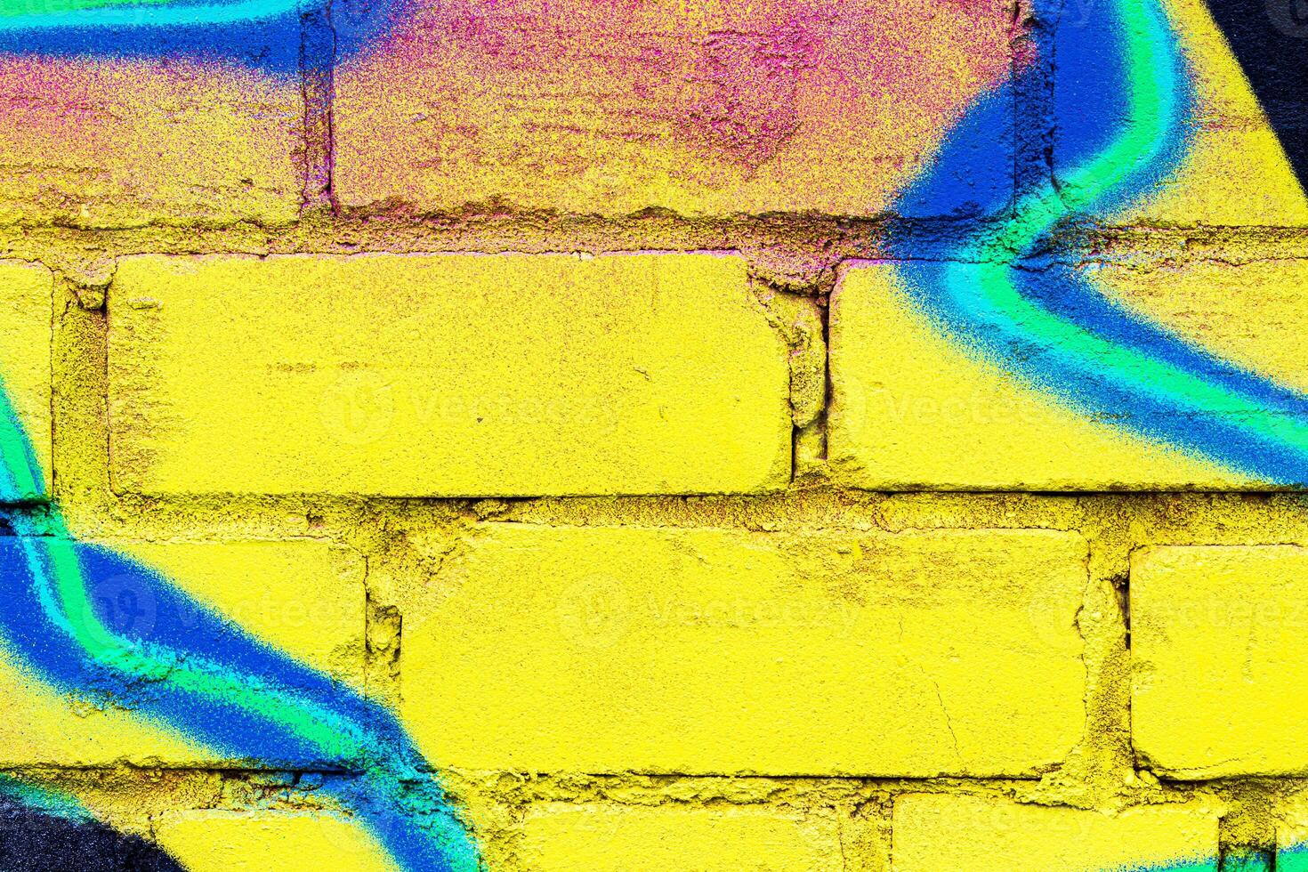 A fragment of colorful graffiti painted on a brick wall. Abstract backdrop for design. photo