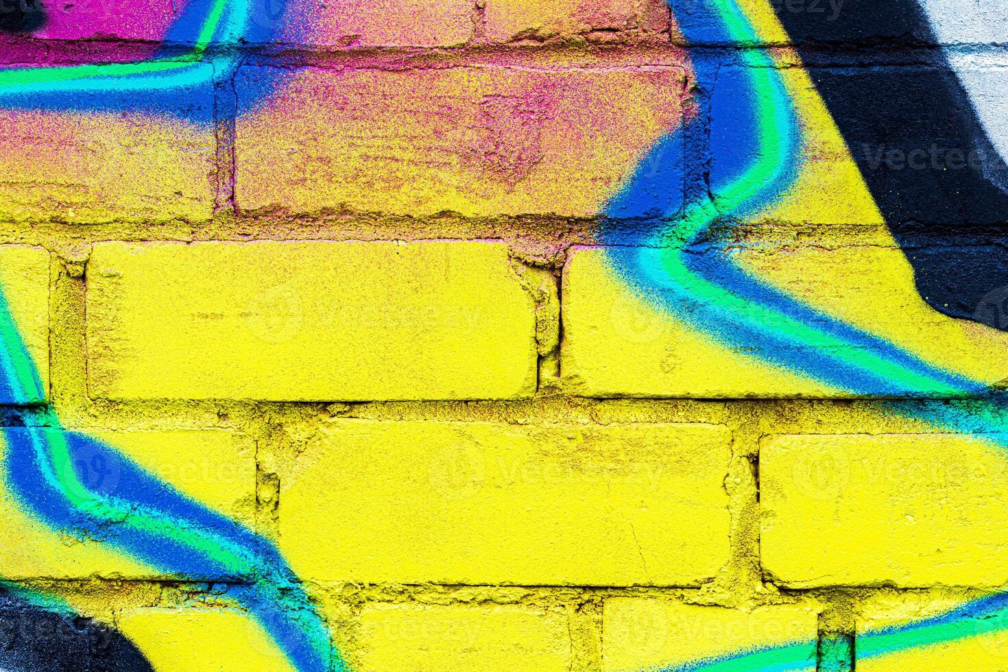 A fragment of colorful graffiti painted on a brick wall. Abstract backdrop for design. photo