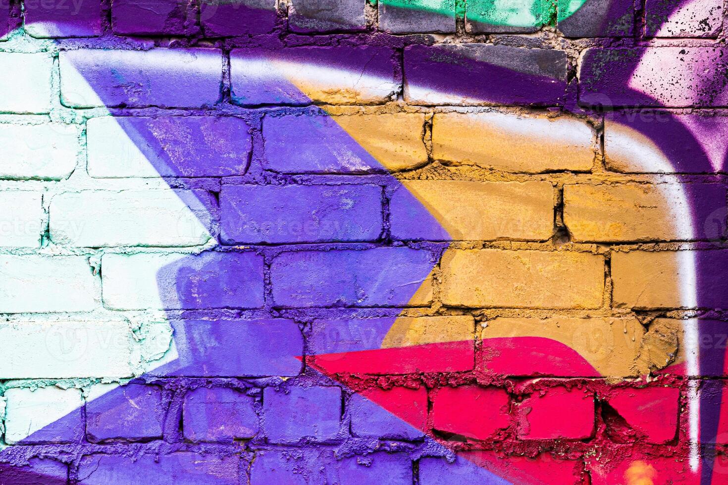 A fragment of colorful graffiti painted on a brick wall. Abstract backdrop for design. photo