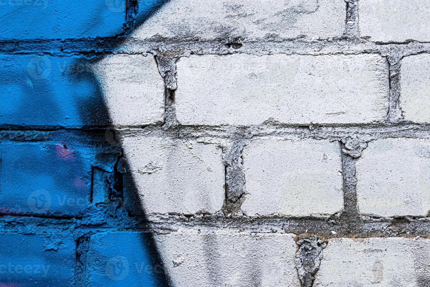 A fragment of colorful graffiti painted on a brick wall. Abstract backdrop for design. photo