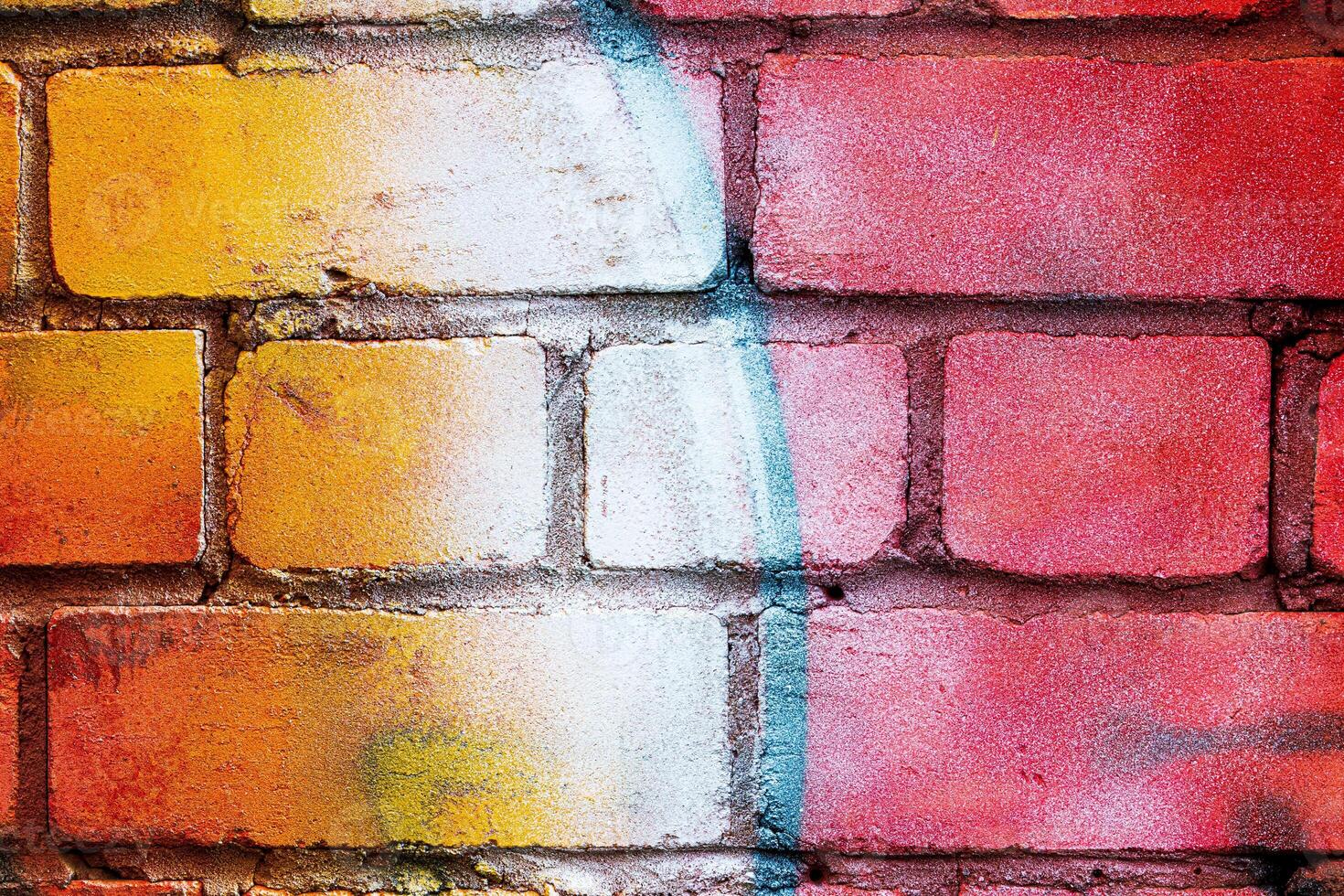 A fragment of colorful graffiti painted on a brick wall. Abstract backdrop for design. photo