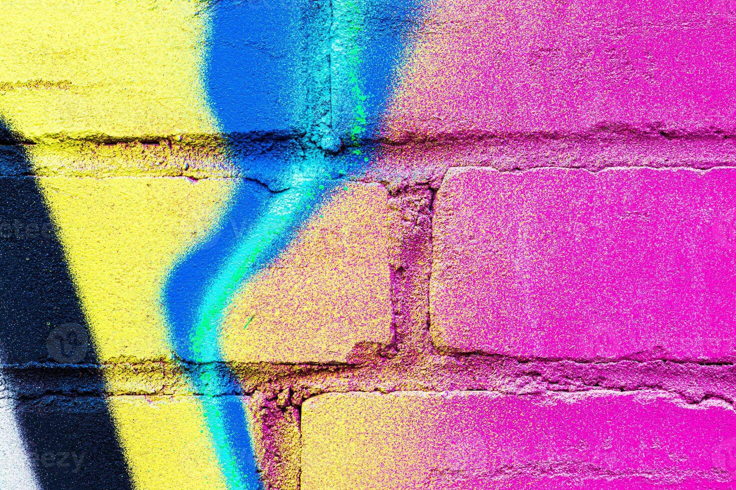 A fragment of colorful graffiti painted on a brick wall. Abstract backdrop for design. photo