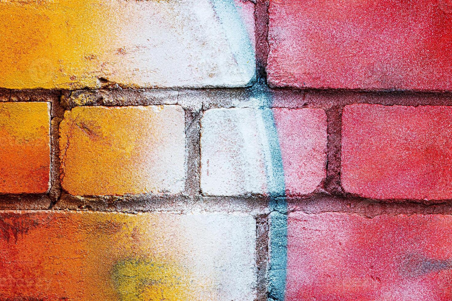 A fragment of colorful graffiti painted on a brick wall. Abstract backdrop for design. photo