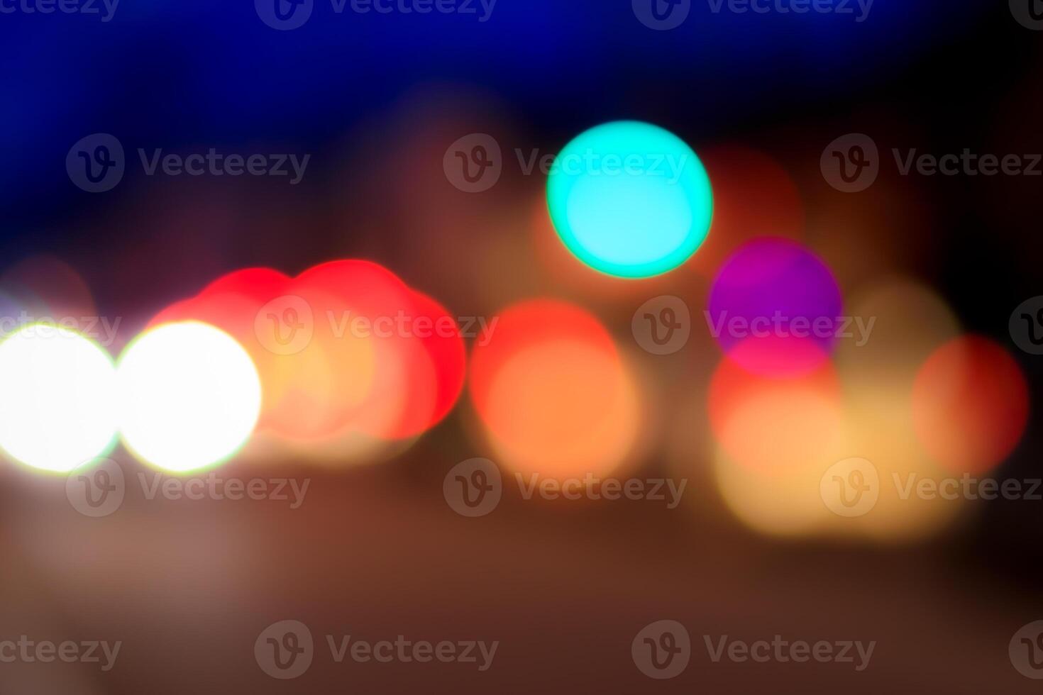 Blurred lights of headlights of cars and lanterns in the night city. Abstract bokeh. photo