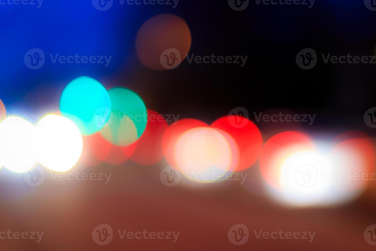 Blurred lights of headlights of cars and lanterns in the night city. Abstract bokeh. photo