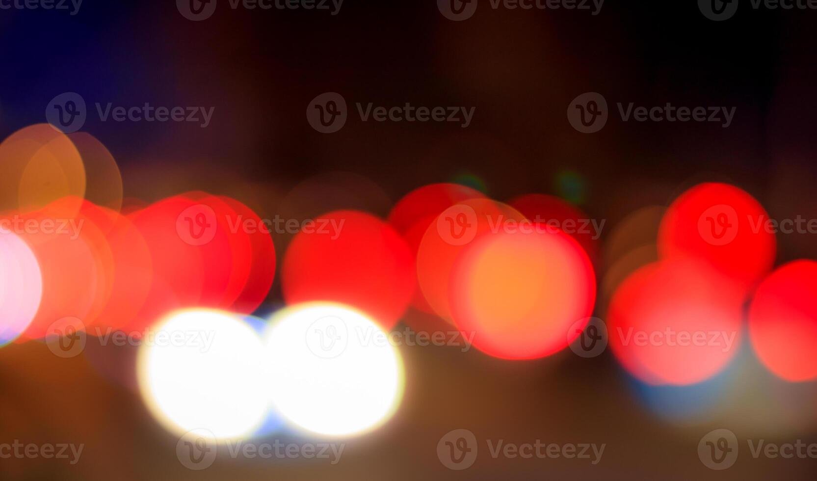 Blurred lights of headlights of cars and lanterns in the night city. Abstract bokeh. photo