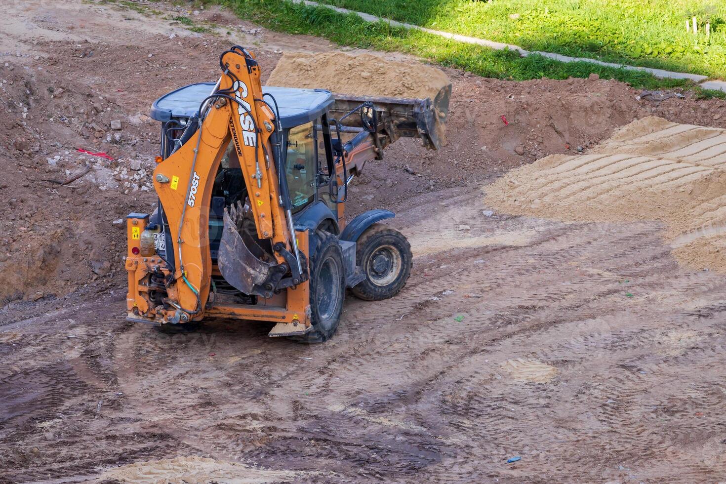 Russia, Kaluga - OCTOBER 27, 2020 A tractor with a bucket leveling a plot of land for construction. photo