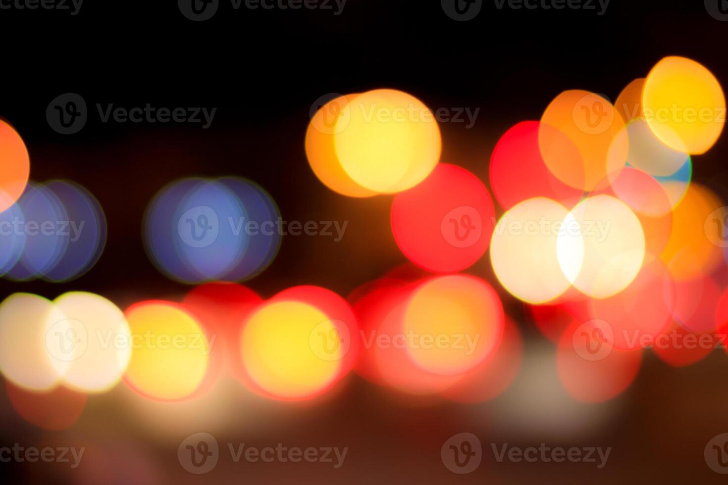Blurred lights of headlights of cars and lanterns in the night city. Abstract bokeh. photo