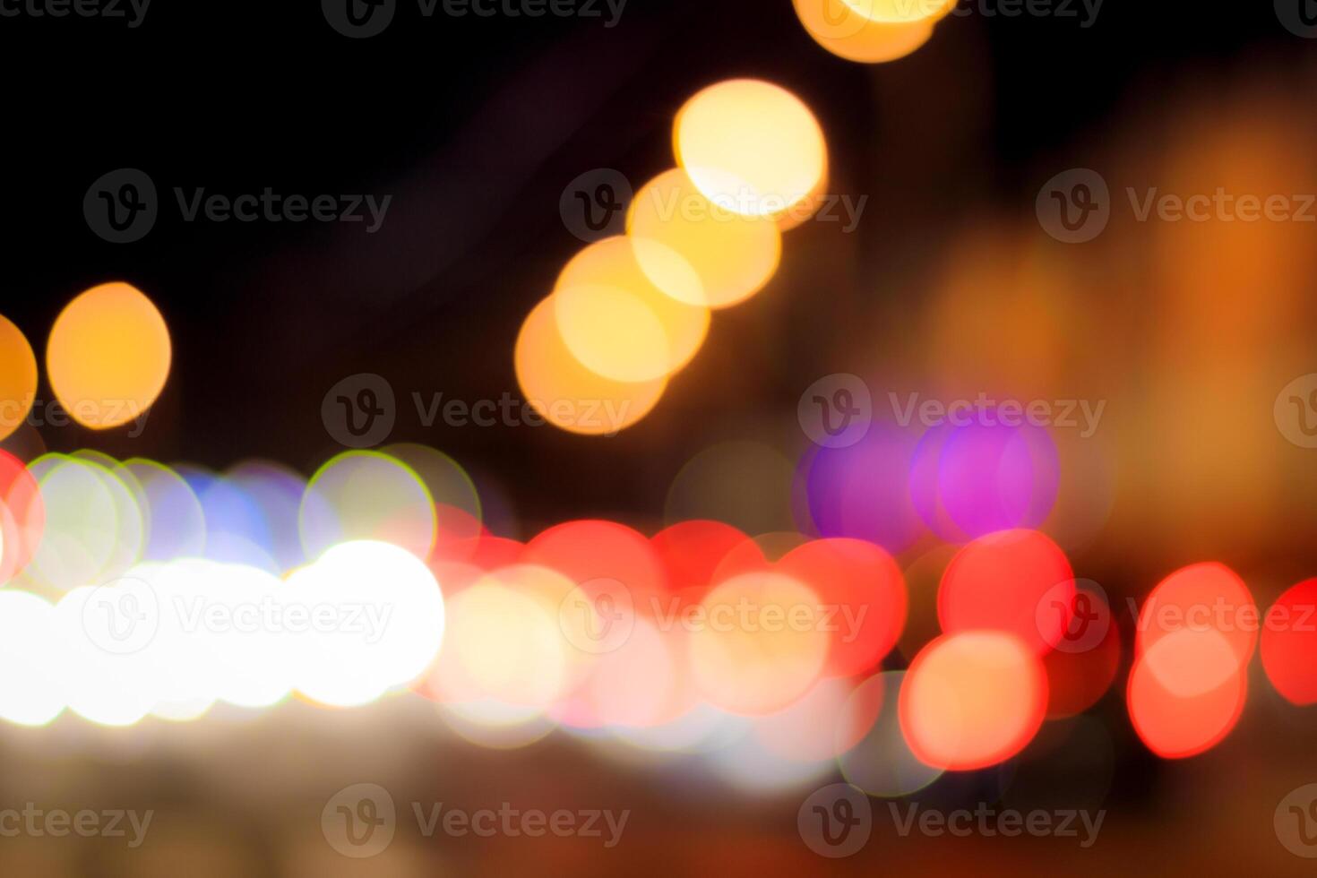 Blurred lights of headlights of cars and lanterns in the night city. Abstract bokeh. photo
