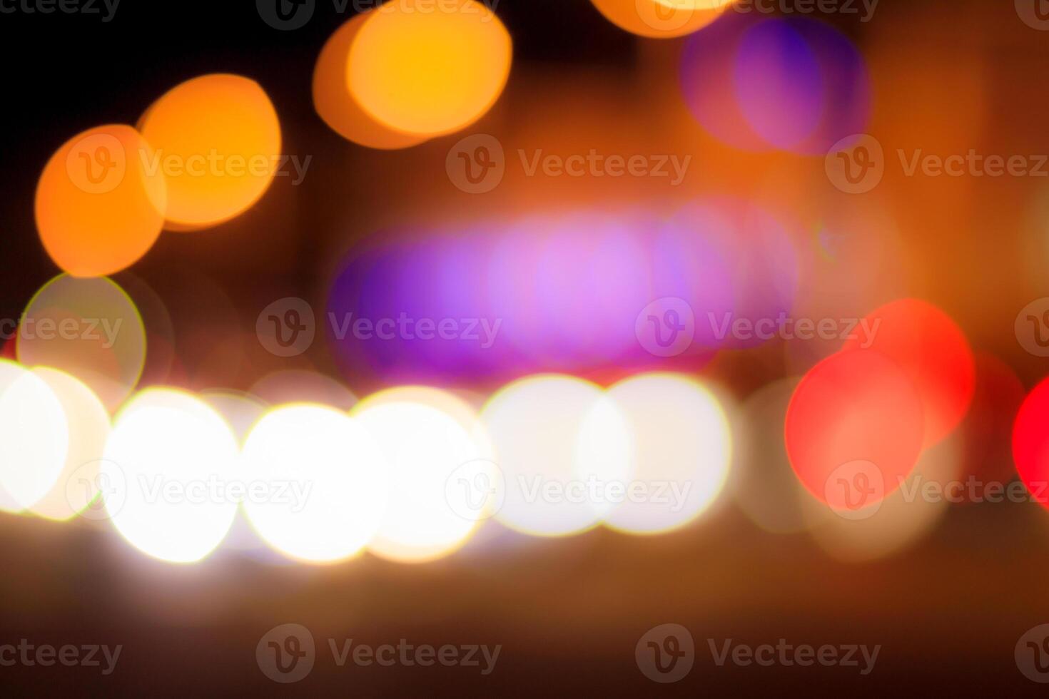 Blurred lights of headlights of cars and lanterns in the night city. Abstract bokeh. photo