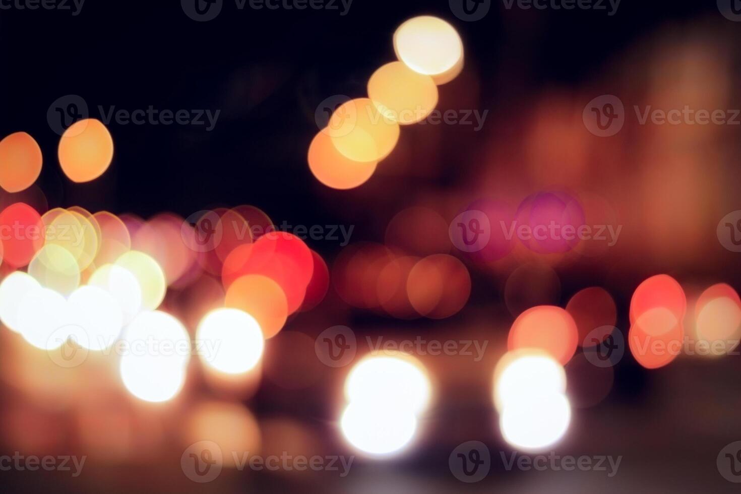 Blurred lights of headlights of cars and lanterns in the night city. Abstract bokeh. photo