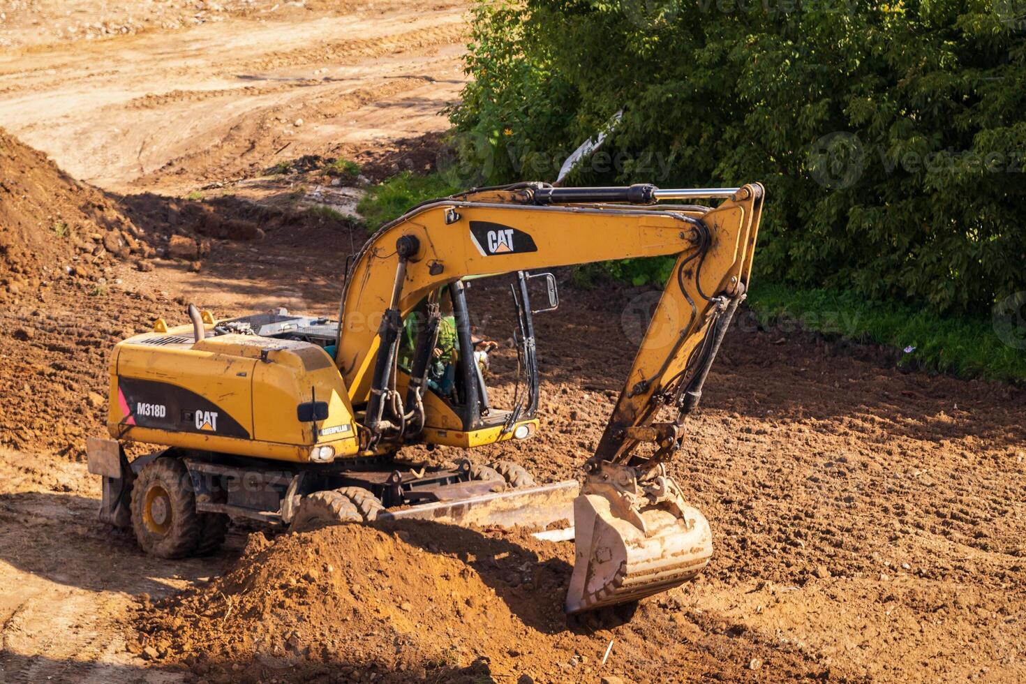 Russia, Kaluga - OCTOBER 27, 2020 A tractor with a bucket leveling a plot of land for construction. photo