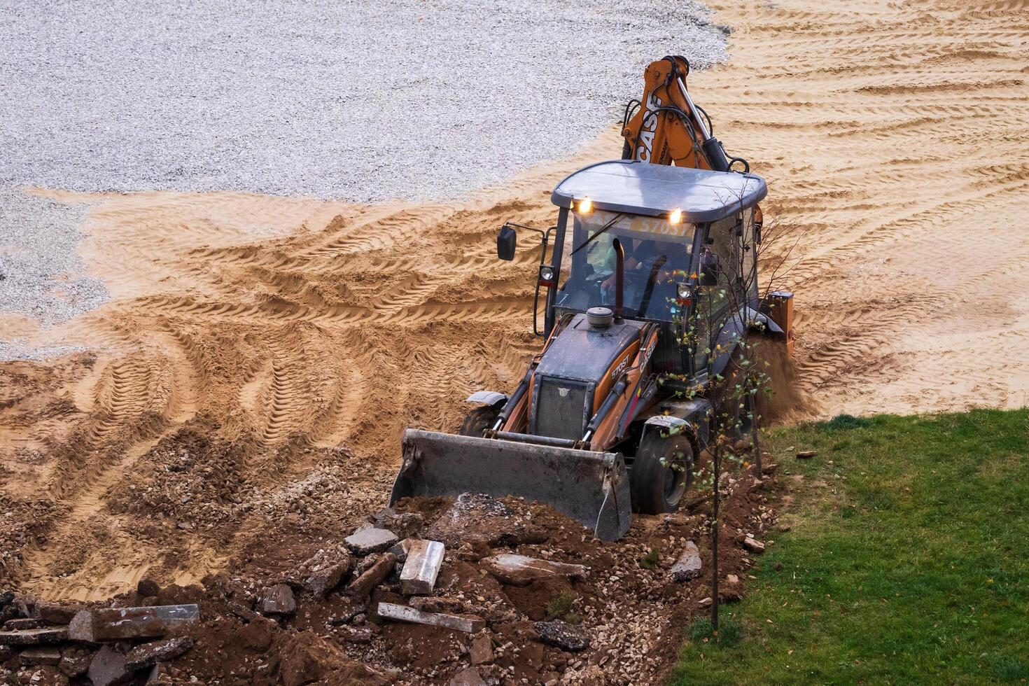 Russia, Kaluga - OCTOBER 27, 2020 Tractor breaking the old asphalt with a bucket before the construction. photo