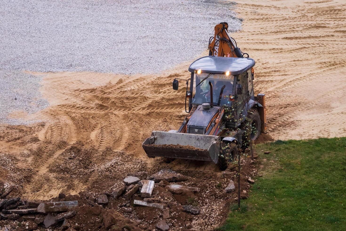Russia, Kaluga - OCTOBER 27, 2020 Tractor breaking the old asphalt with a bucket before the construction. photo