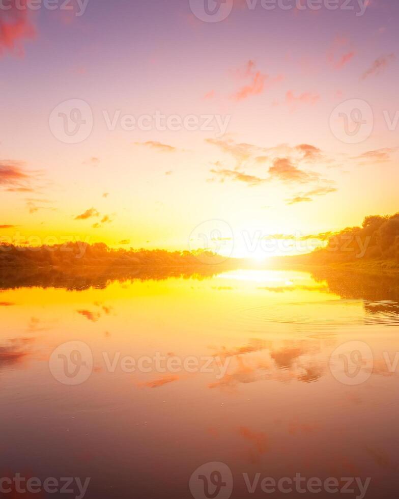 A sunset or sunrise scene over a lake or river with dramatic cloudy skies reflecting in the water on a summer evening or morning. photo