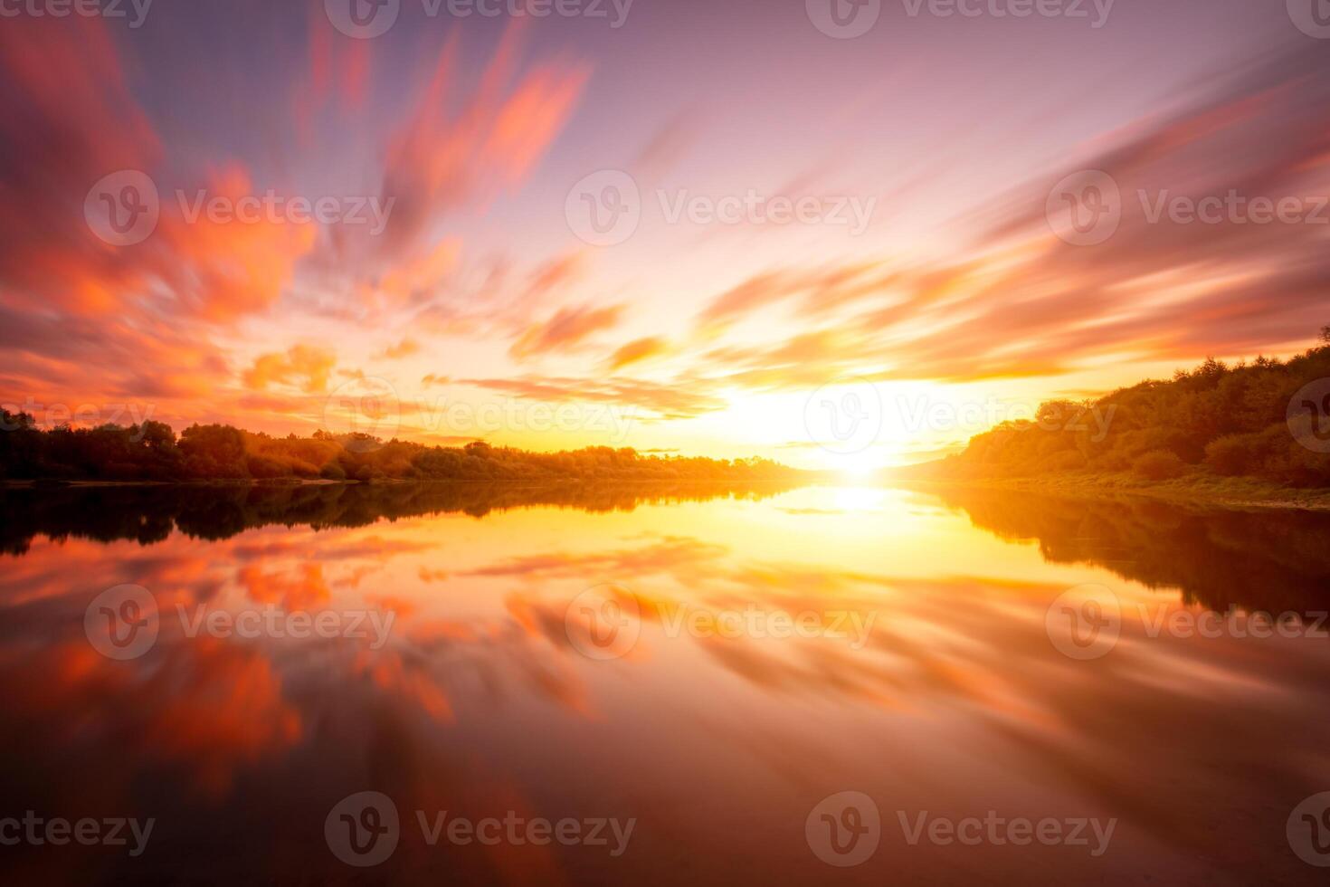 A sunset or sunrise scene over a lake or river with dramatic cloudy skies reflecting in the water on a summer evening or morning. photo
