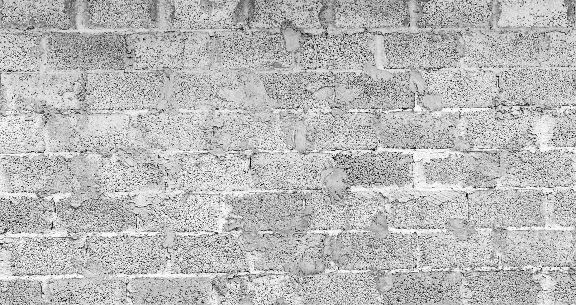 Monochrome texture of a wall made of concrete blocks connected cement. Abstract black and white background. photo