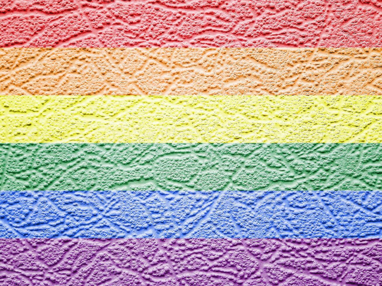 Rainbow LGBTQ or gay pride flag on wallpaper texture. Abstract background. photo