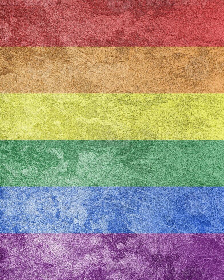 Rainbow LGBTQ or gay pride flag on decorative plaster or concrete texture. Abstract background. photo